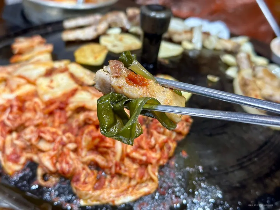 Kimchi and onions grilled together on the cauldron-lid plate