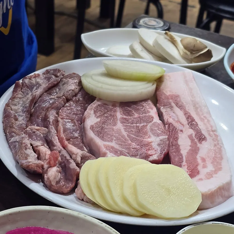 Table setting of whole-leaf kimchi, wrap vegetables, and other side dishes
