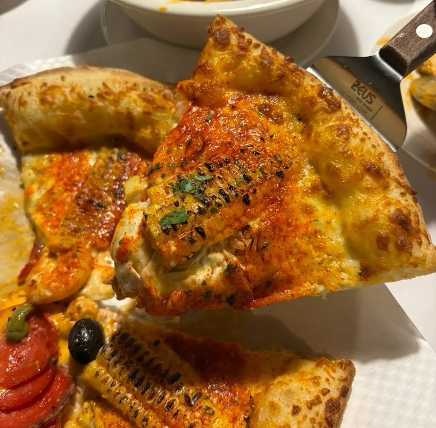 Corn pizza topped with one piece of corn per slice