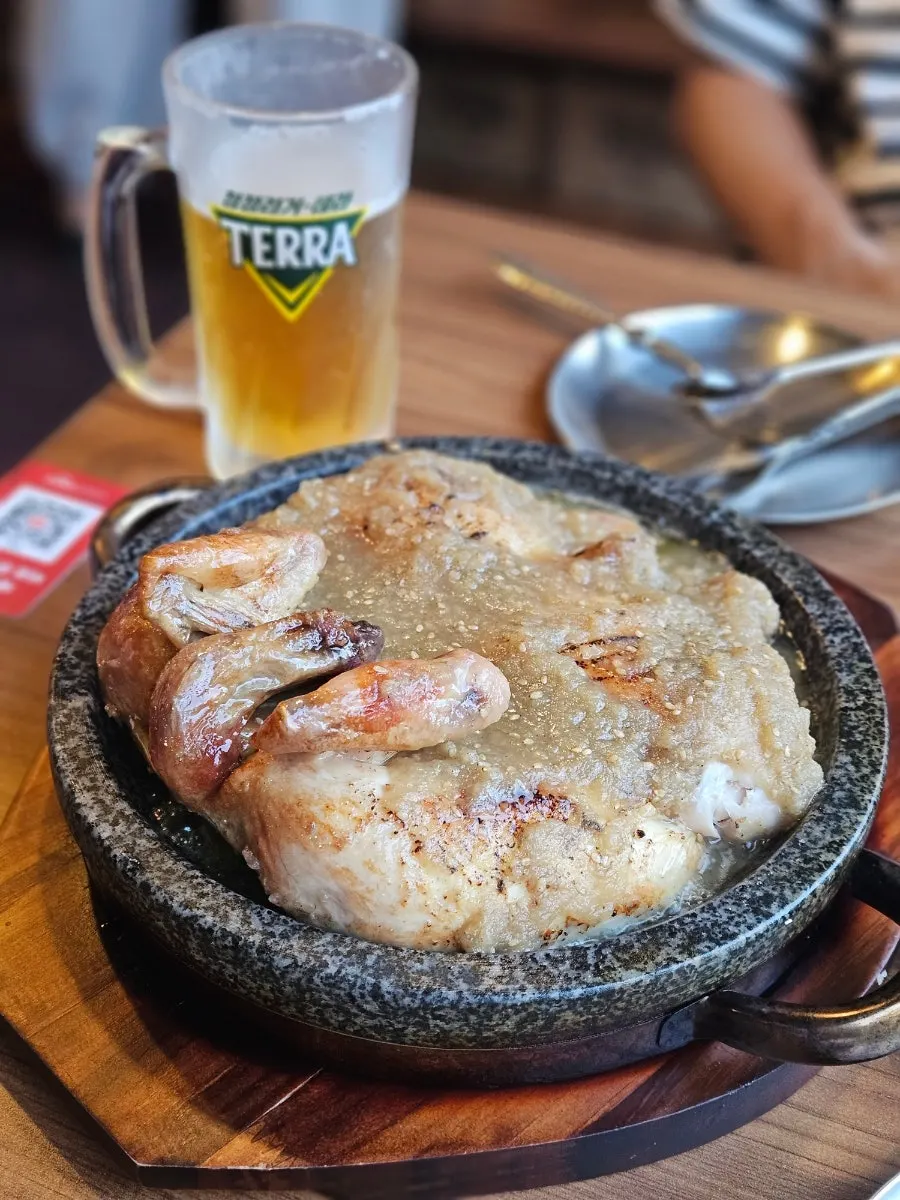 Suwon wang-galbi oak-fired chicken served on a stone plate