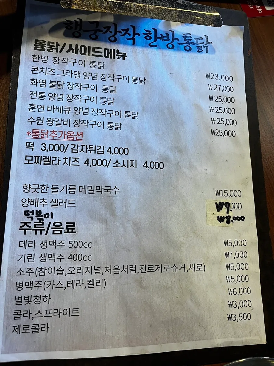 Menu board listing the price of the herbal oak-fired chicken