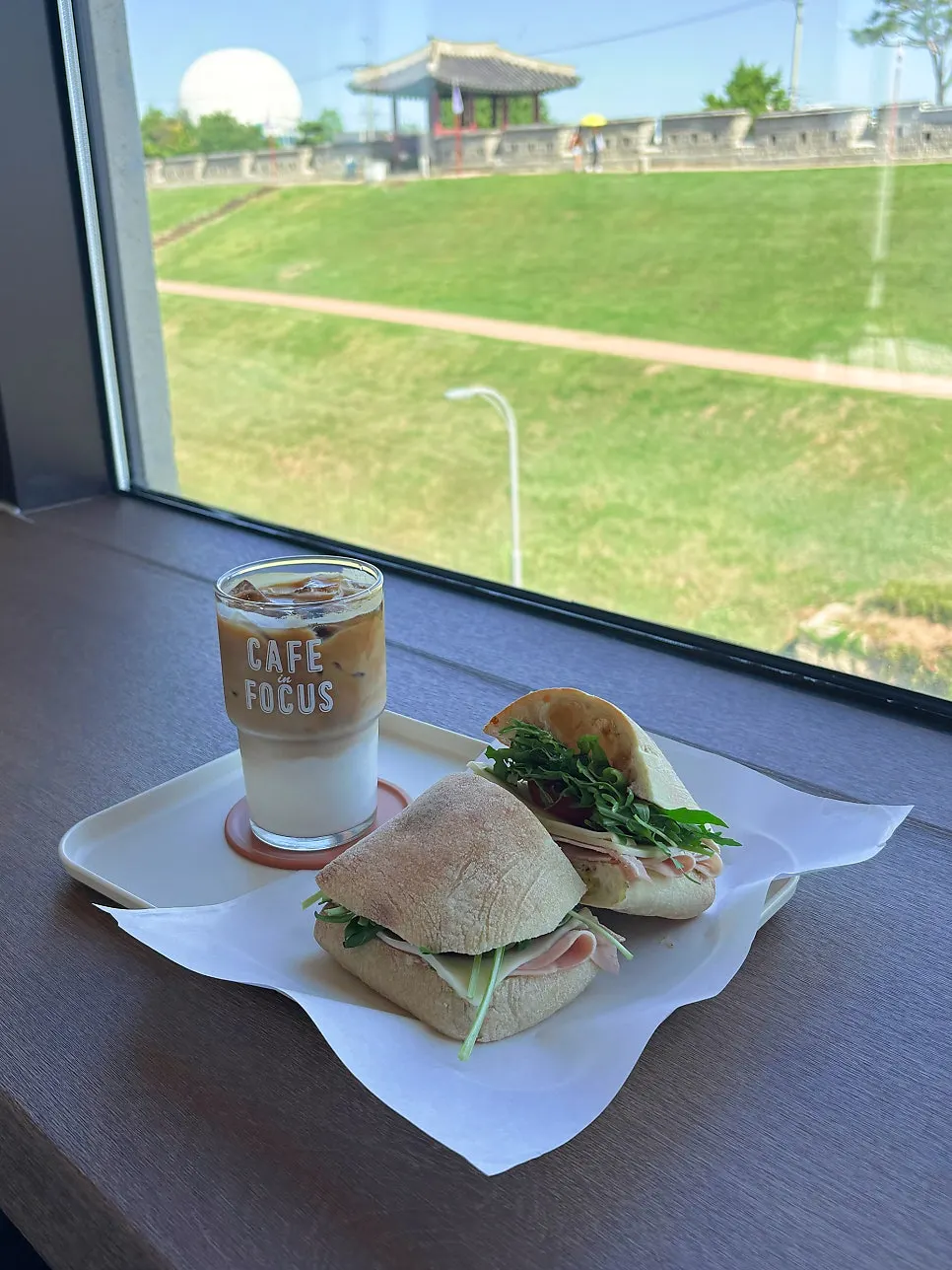 Latte and sandwich set on the window-side table