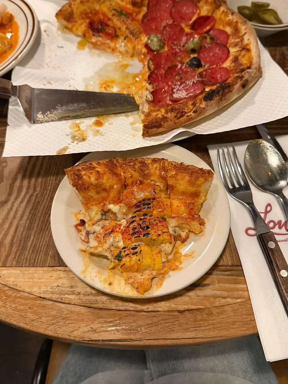 A slice of pizza loaded with corn topping