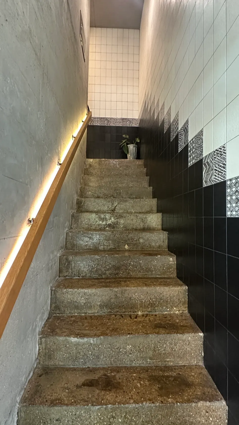 Staircase with concrete walls and wood railings