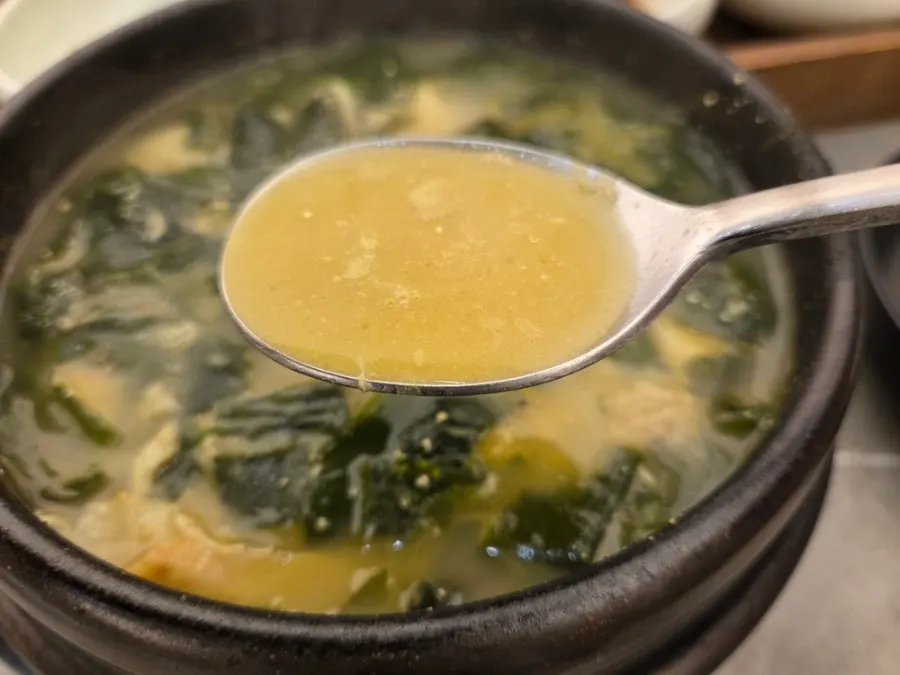 Broth showing seaweed and pieces of flounder