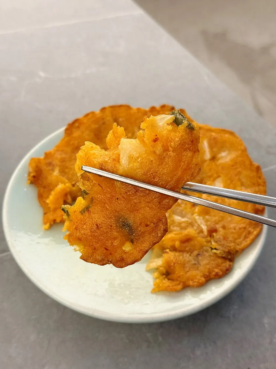 한 조각 집어든 김치전