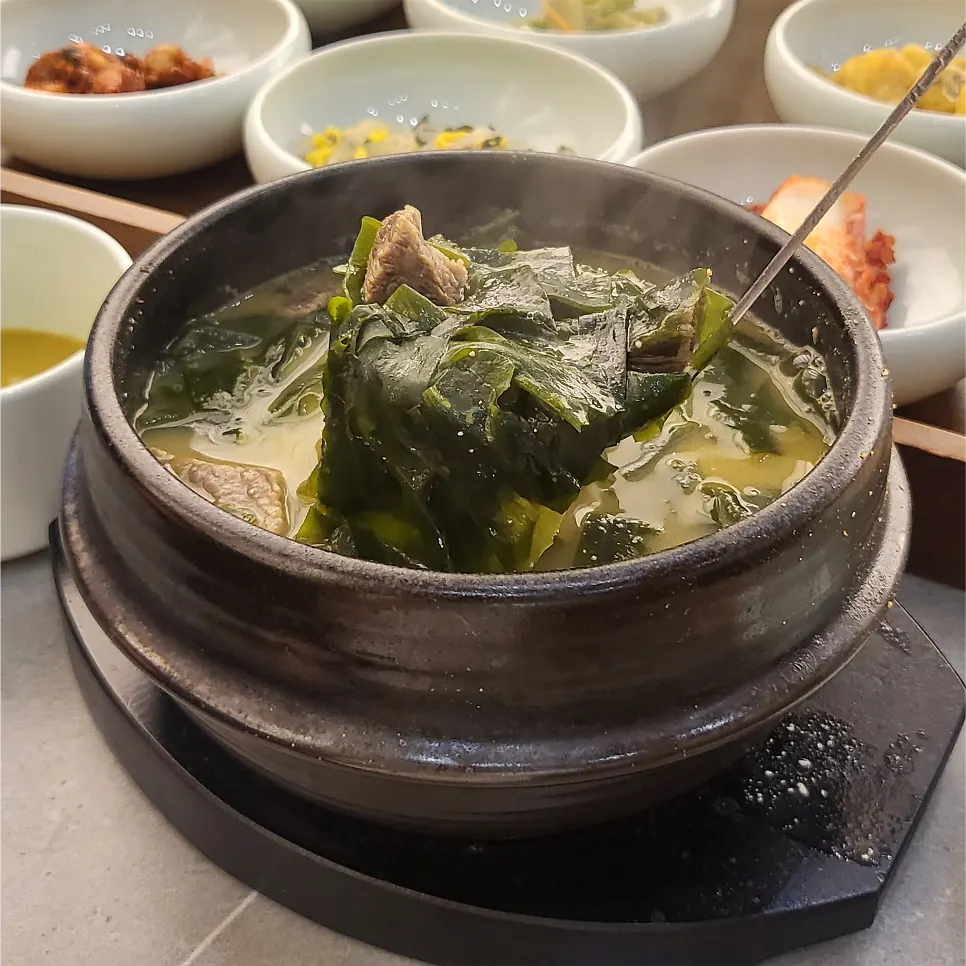 Rice and 13 banchan laid out with the seaweed soup set
