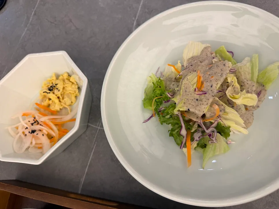 Salad, egg, and stir-fried onion side dishes