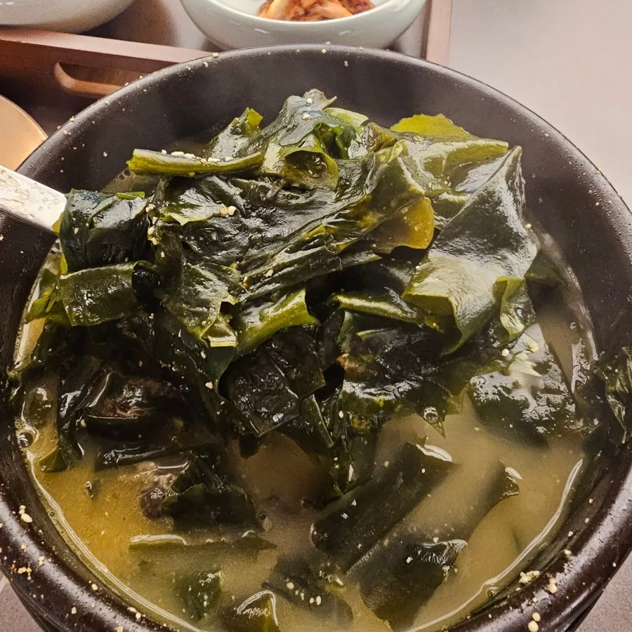 A bowl of scallop seaweed soup with generous fillings