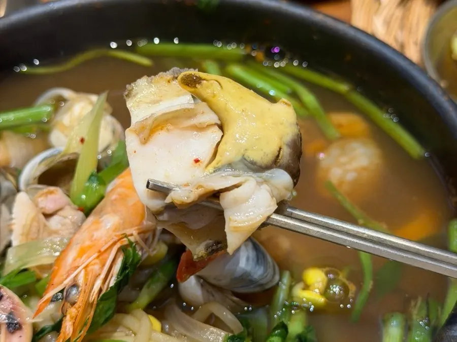 Seafood stew broth ladled into a small dish