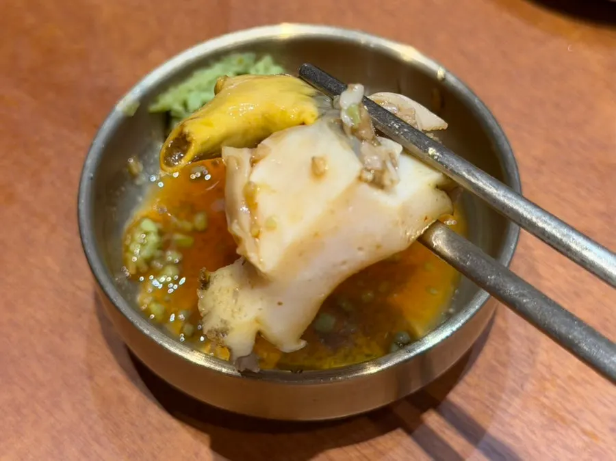 Abalone from the stew dipped in wasabi soy sauce