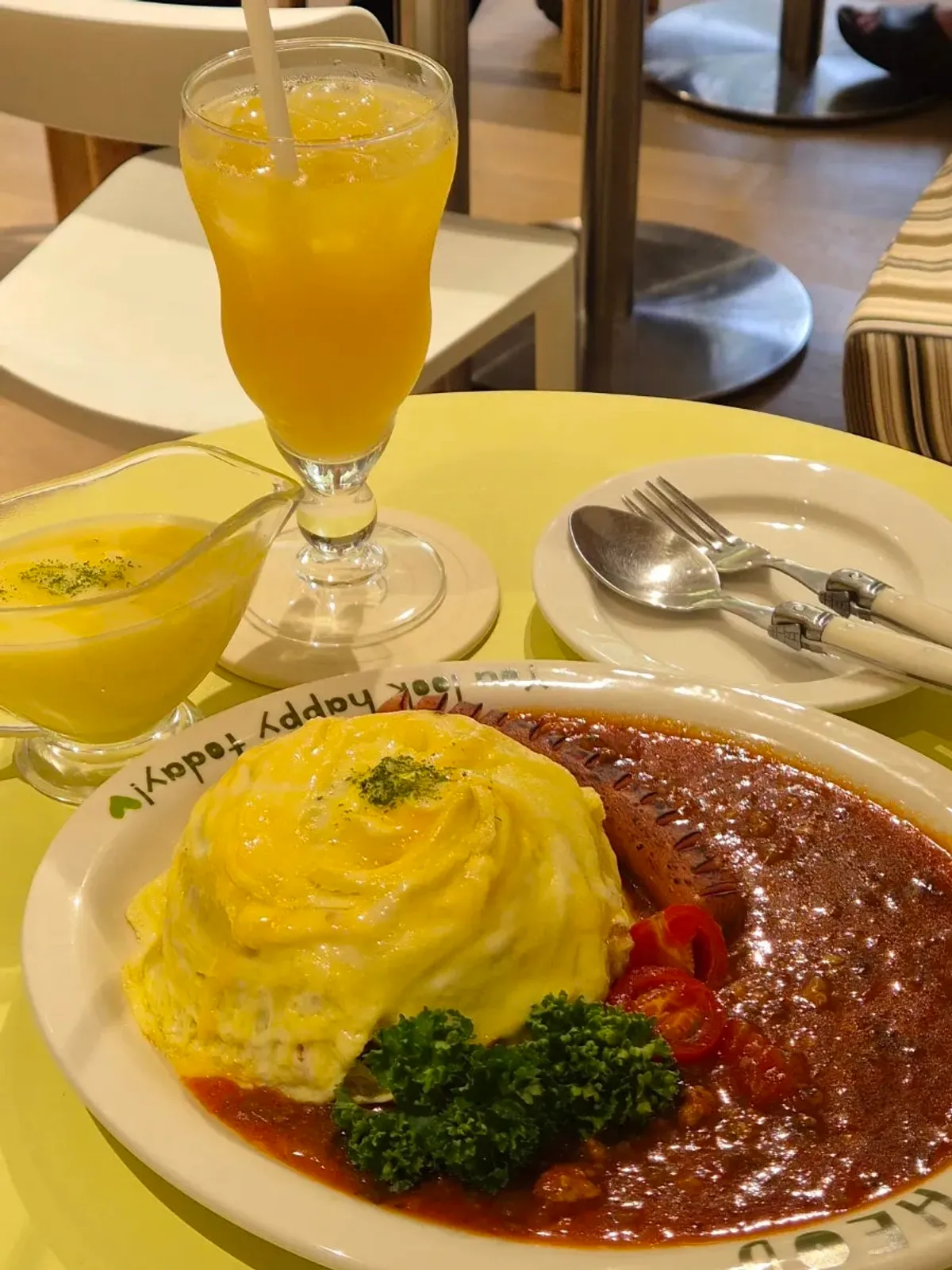HEOD omurice, added mashed potato, and orange juice set on the table