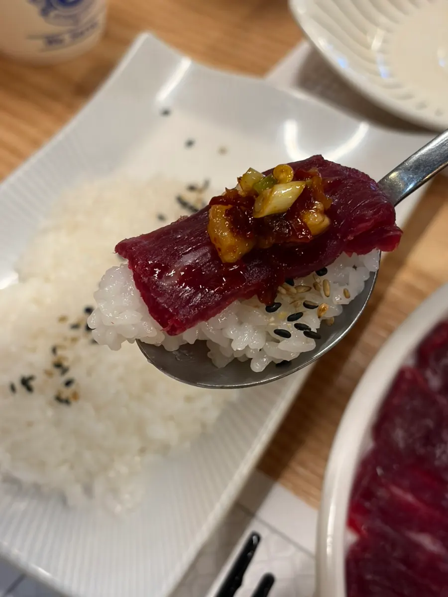 A piece of raw beef dipped in sauce
