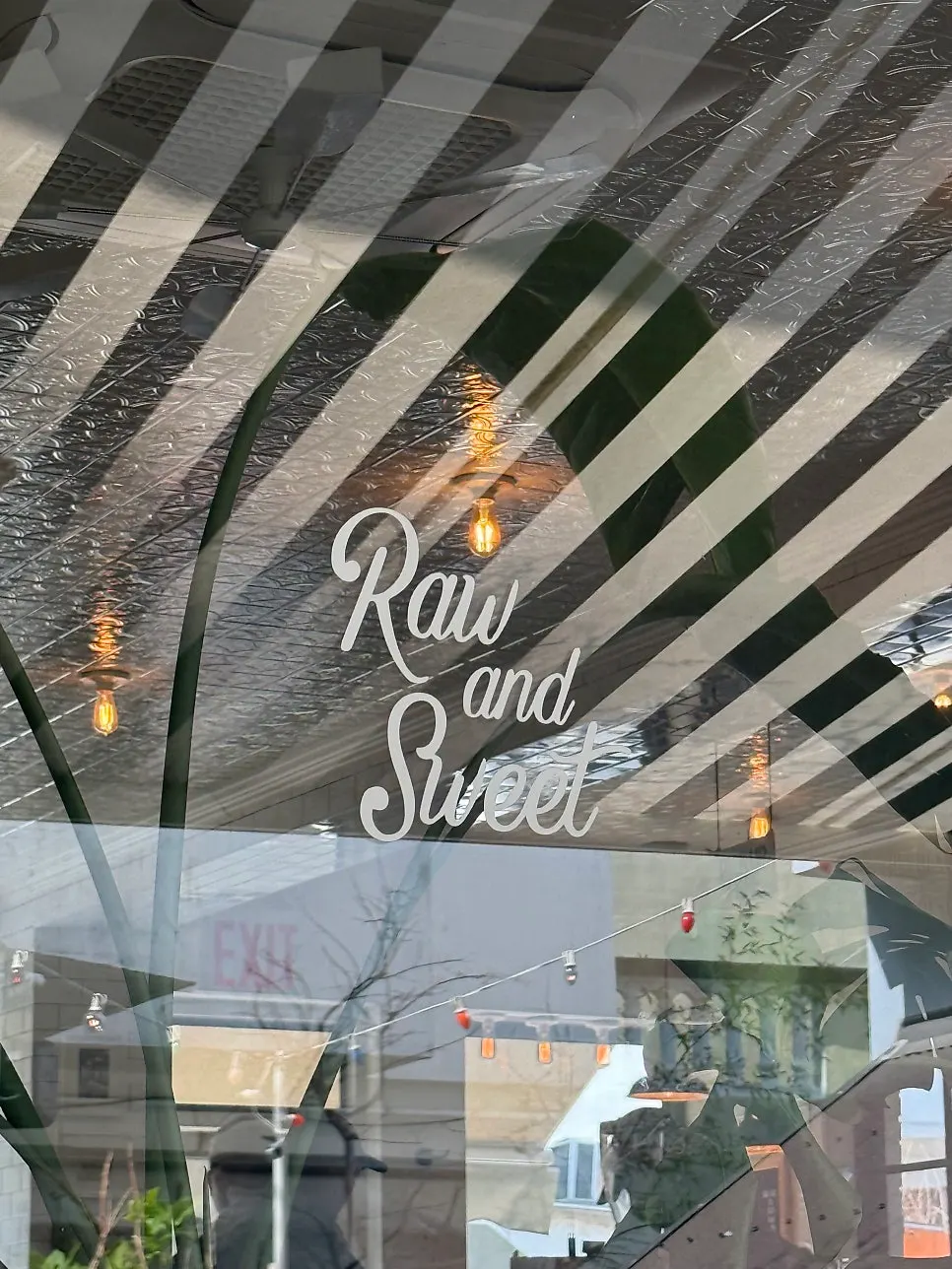Exterior of Low & Sweet Bakery with white walls and a black door