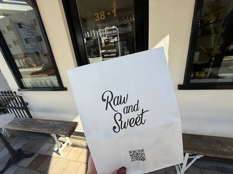 Holding takeout coffee and a dessert bag