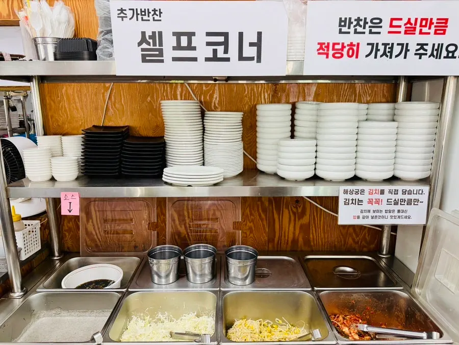 Self-serve side dish corner with kimchi and bean sprouts at Haesanggung