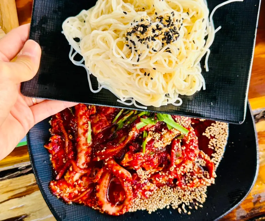 A bite of somyeon noodles mixed with octopus stir-fry sauce