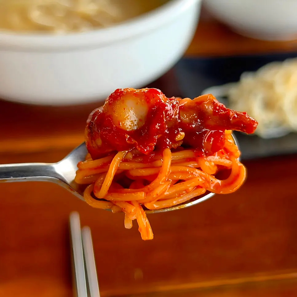 A bite of somyeon mixed with the sauce