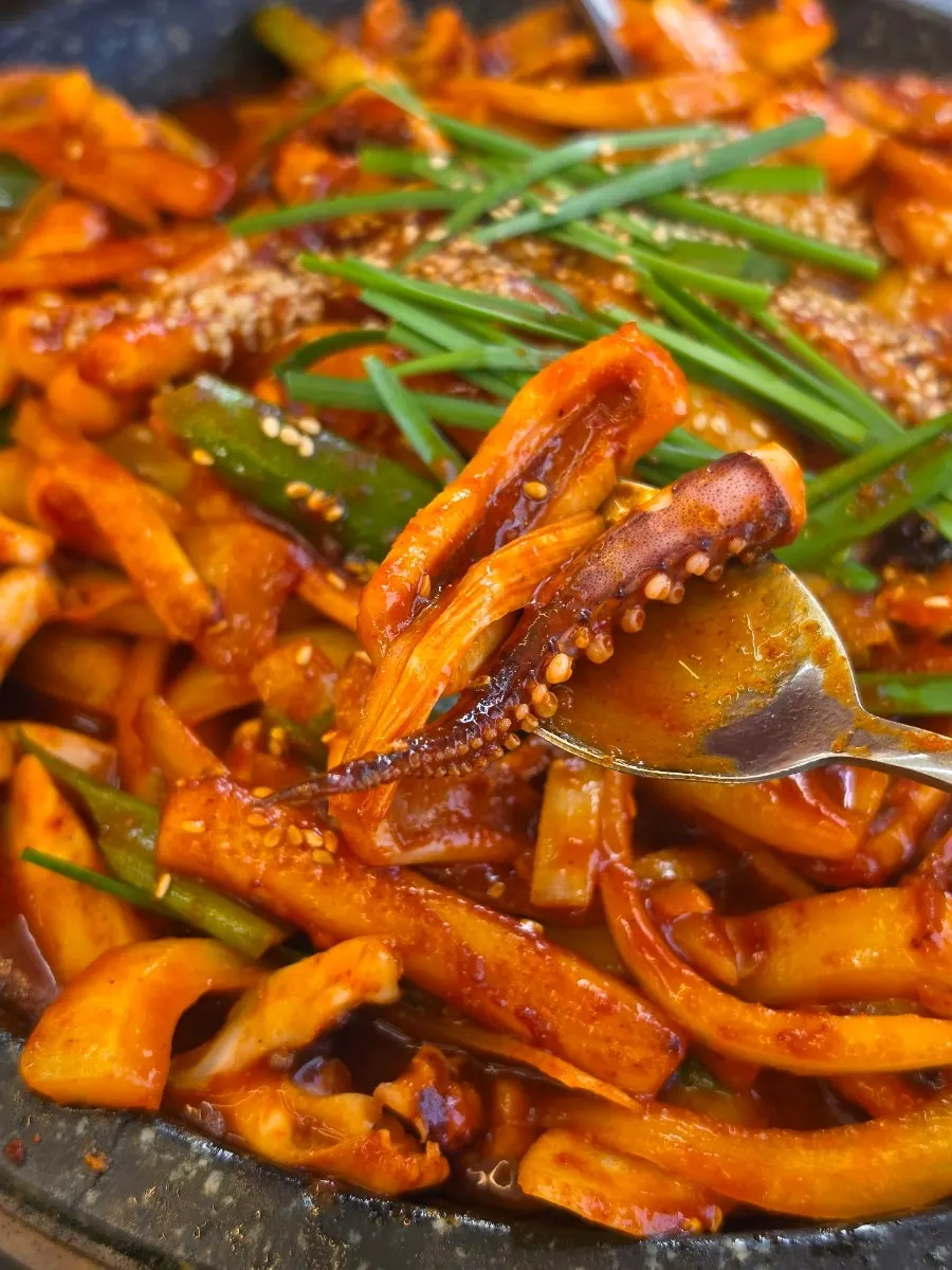 Chopsticks lifting a springy piece of squid