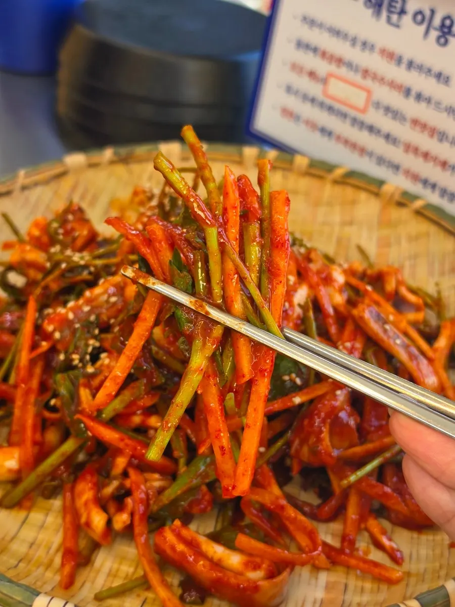 Chopsticks lifting squid vinegar salad with minari