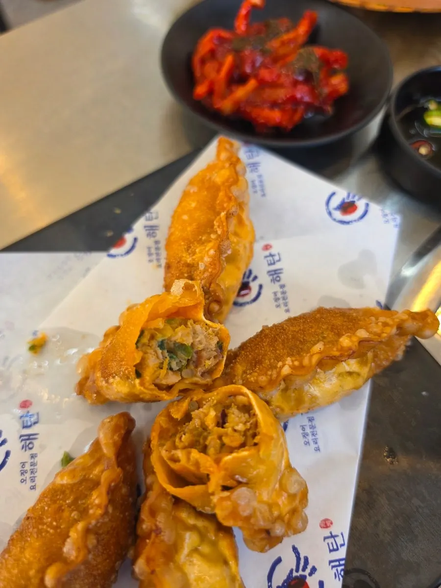 Dipping a fried squid dumpling into hot-plate squid sauce