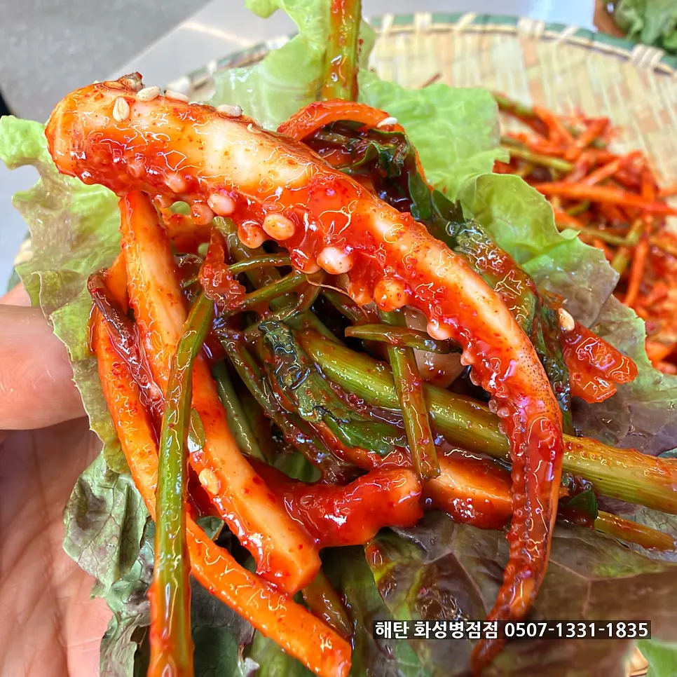 A chopstick-full of squid vinegar salad with minari and vegetables