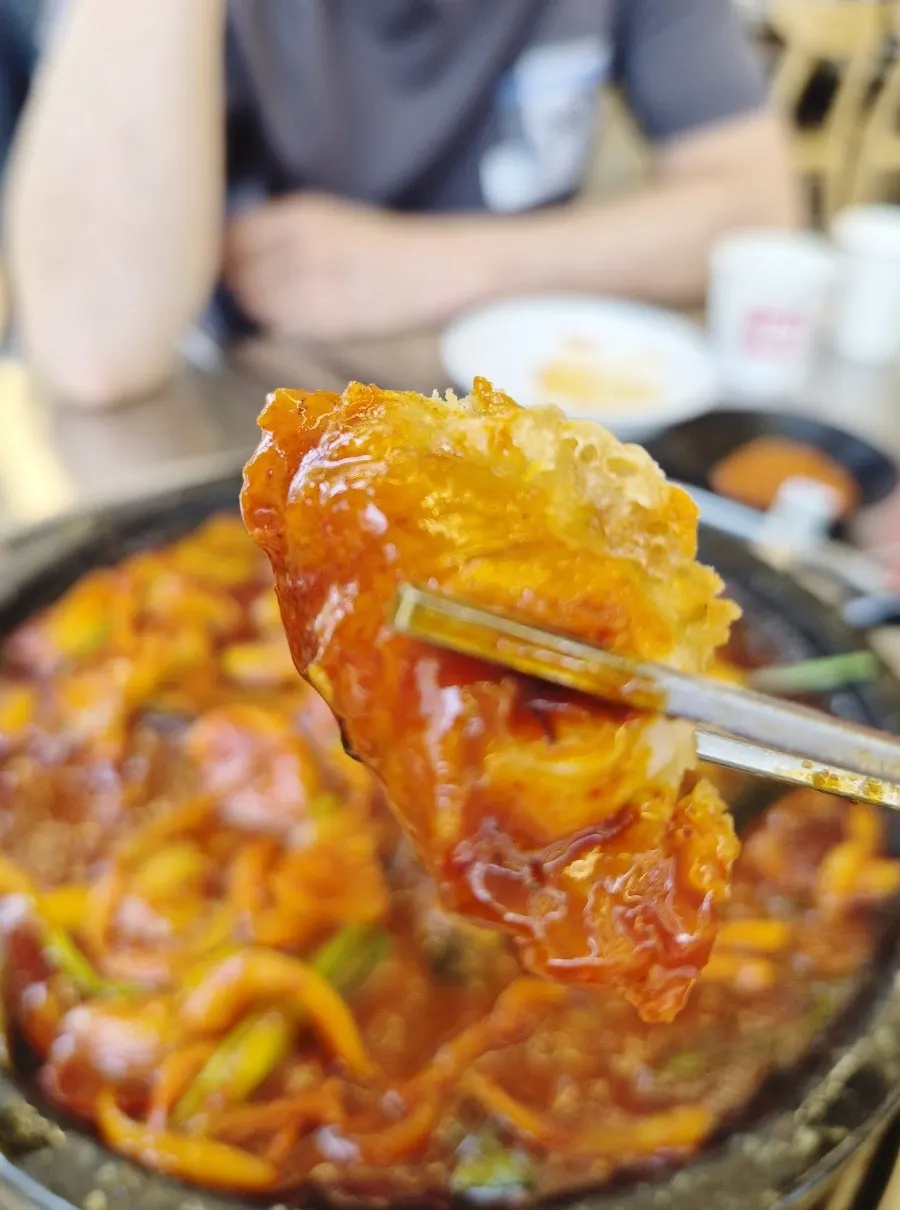 Dipping a squid fritter into the sauce