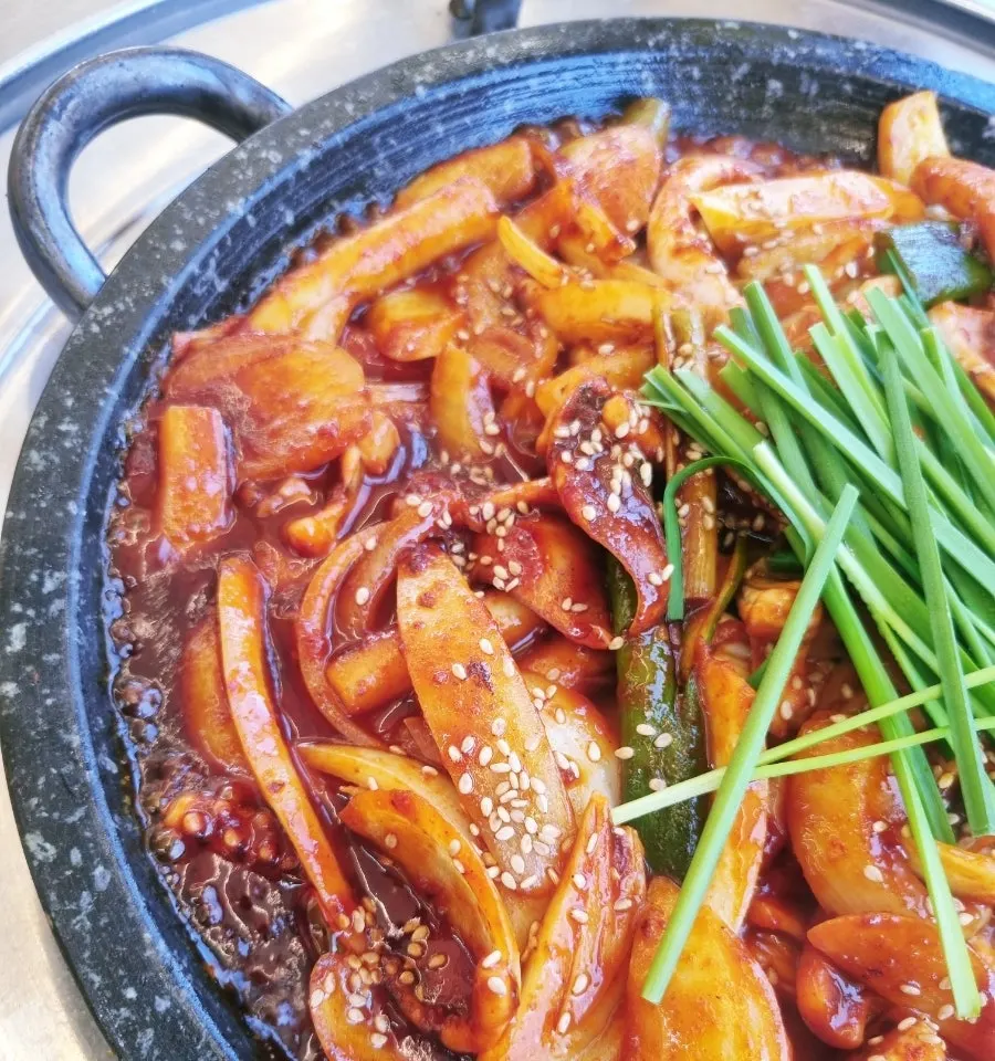 Hot-plate squid stir-fry topped with scallions and sesame seeds