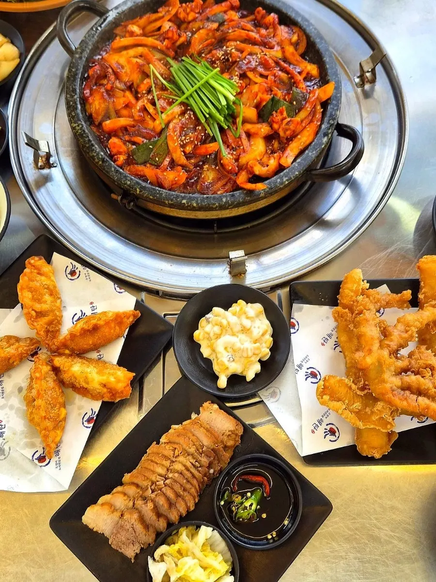 Table spread with stone-plate squid, bossam, and fried squid