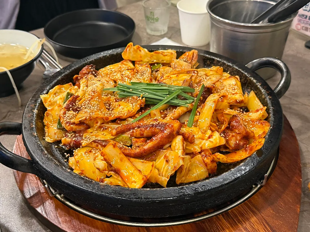 Spicy squid stir-fry served on a hot stone plate