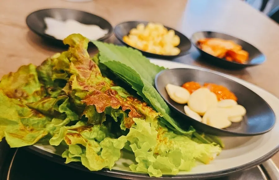 쌈채소와 밑반찬이 차려진 테이블