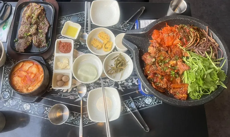 Table spread of the couple set with gochujang pork belly and LA galbi