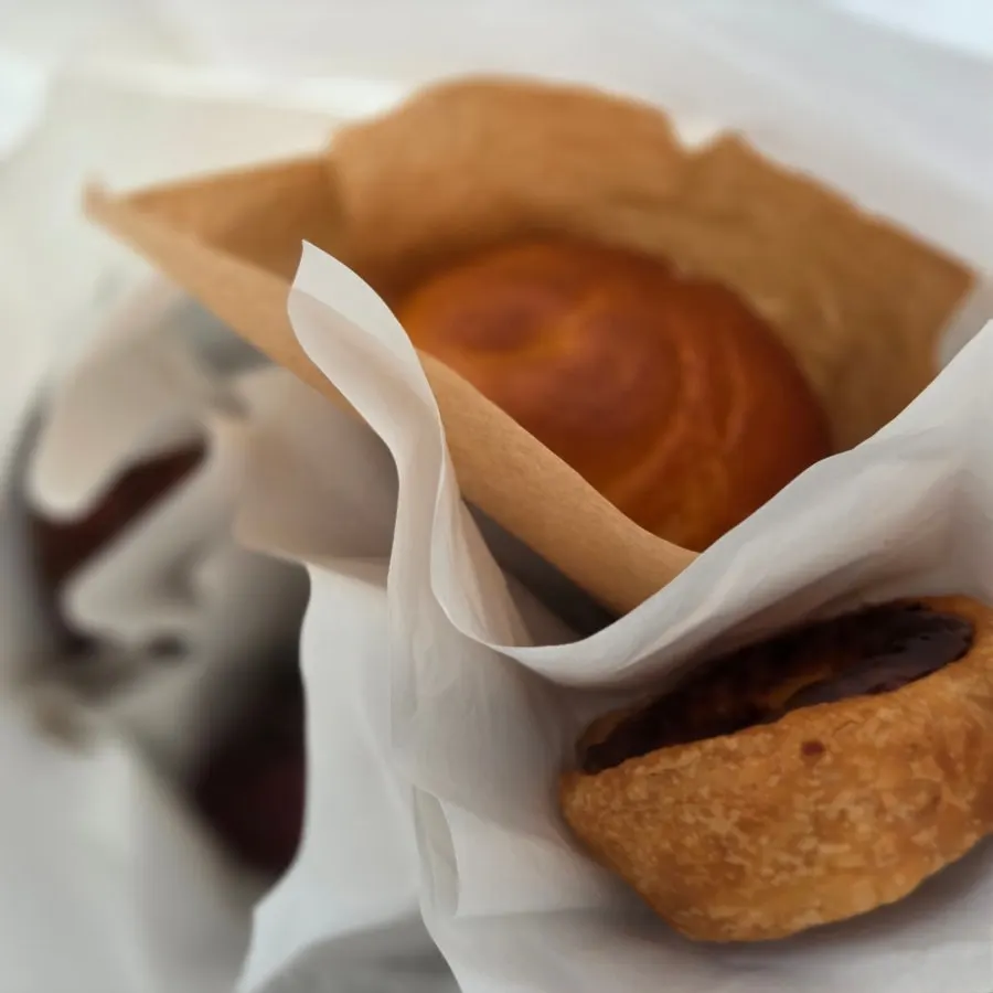 Four pastries packed to go alongside a vanilla bean latte