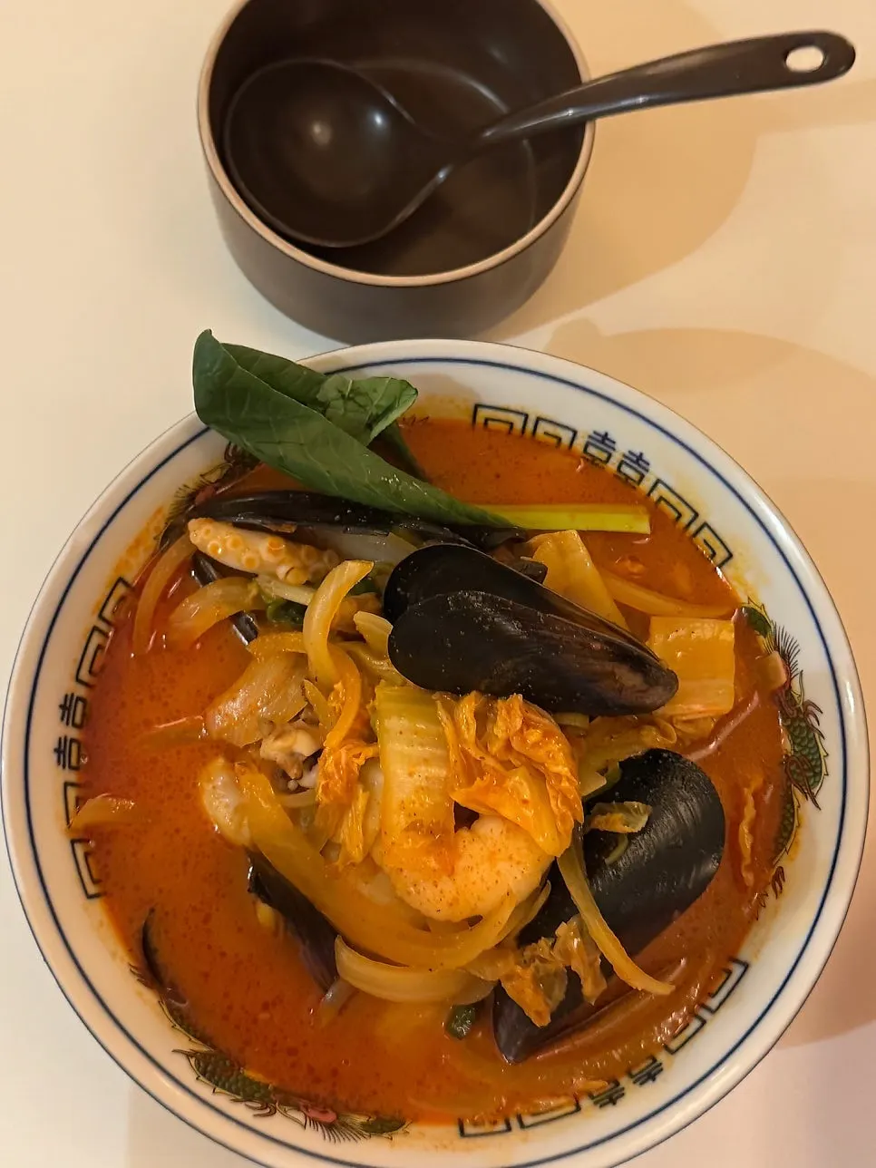 A bowl of seafood jjamppong with a rich broth