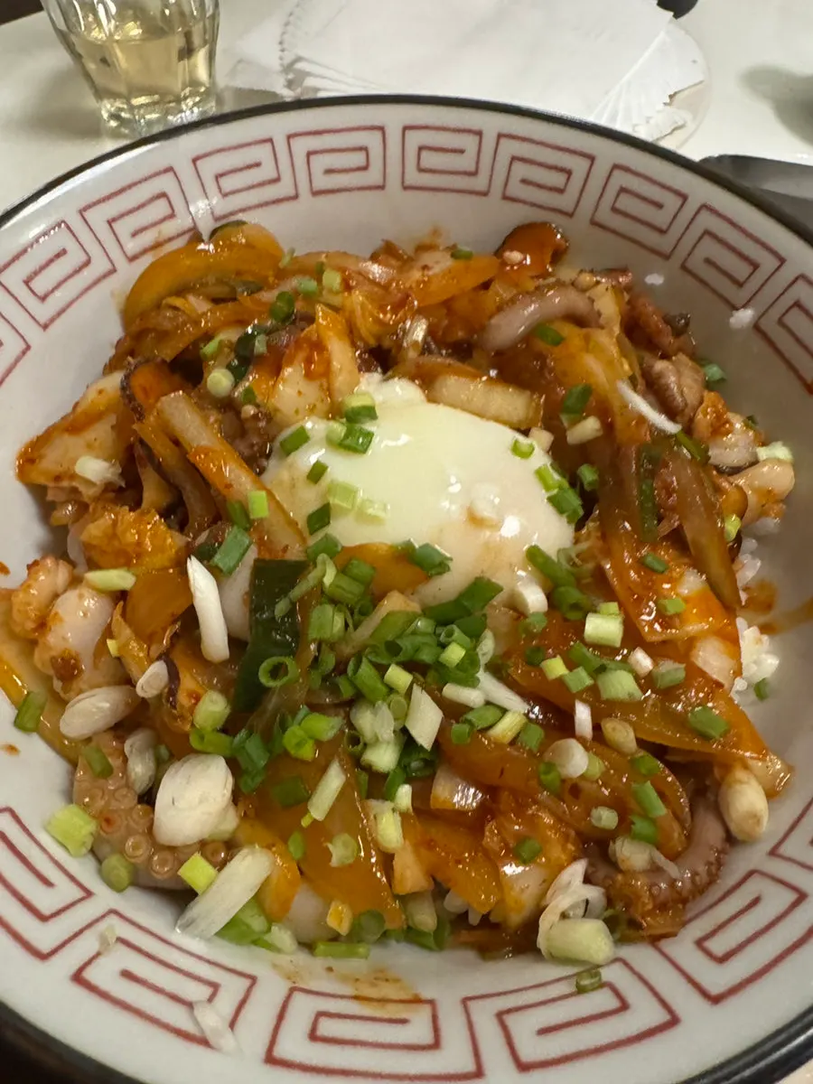 Close-up of jjamppong broth loaded with toppings