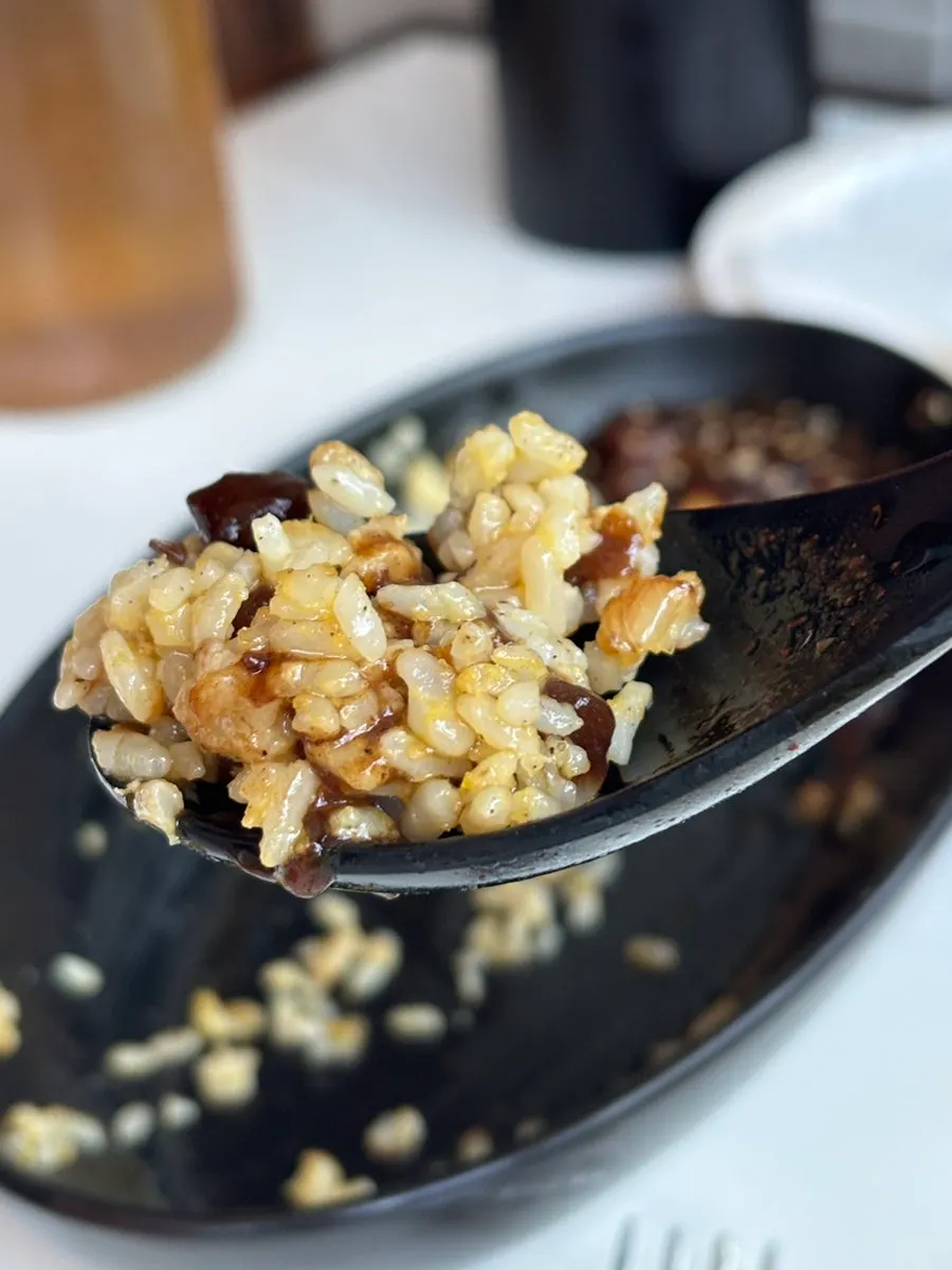 A spoonful of shrimp fried rice with jjajang sauce