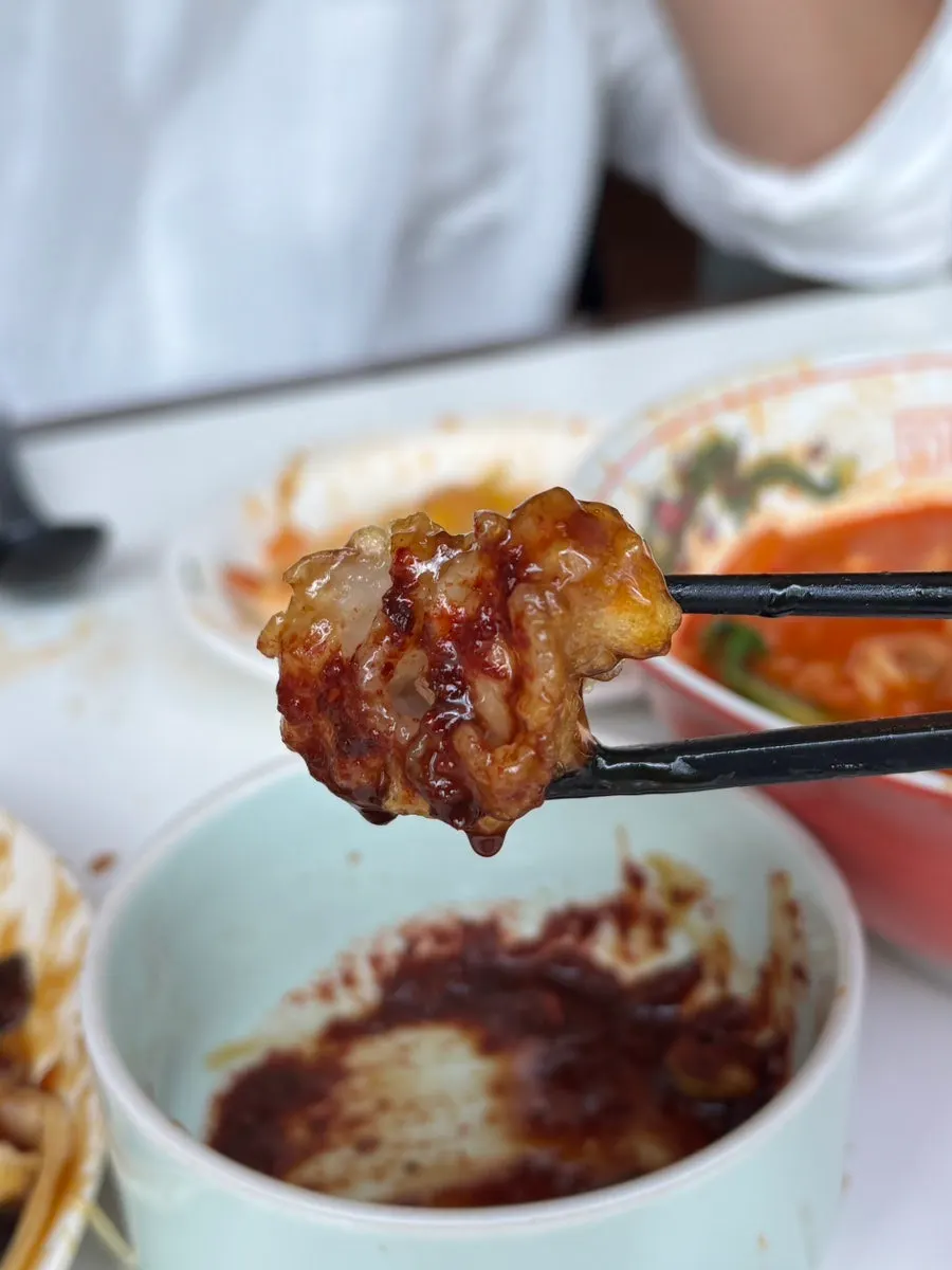 Dipping sweet and sour pork into the soy sauce