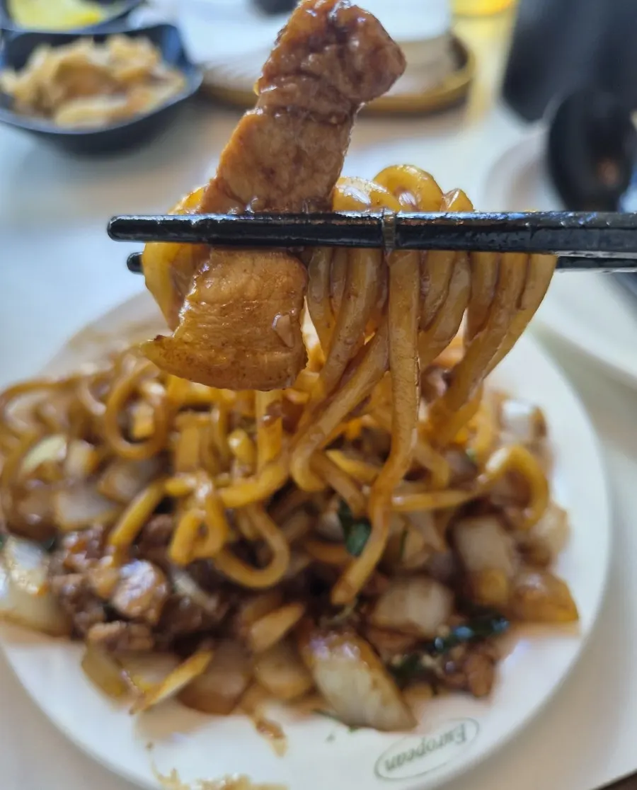 Poached-egg pork belly jjajang topped with shredded cucumber
