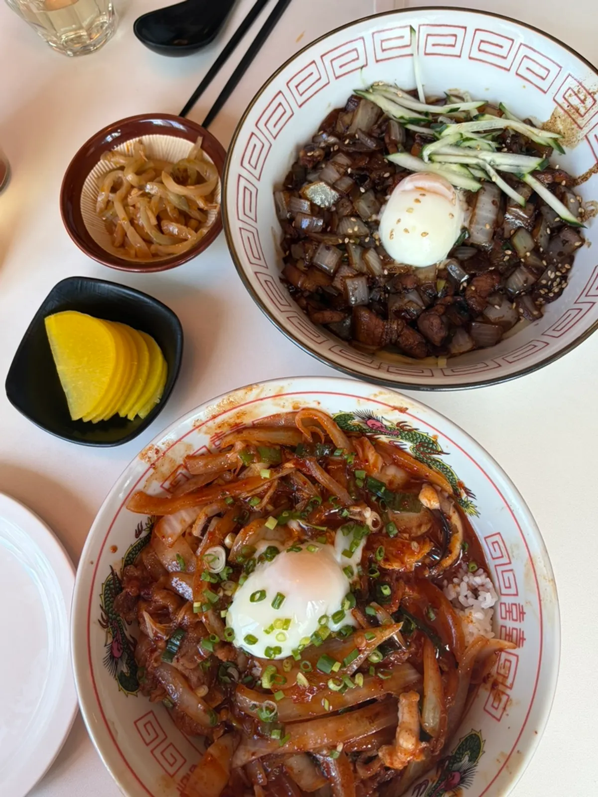 Table spread of poached-egg pork belly jjajang and poached-egg octopus jungwha rice