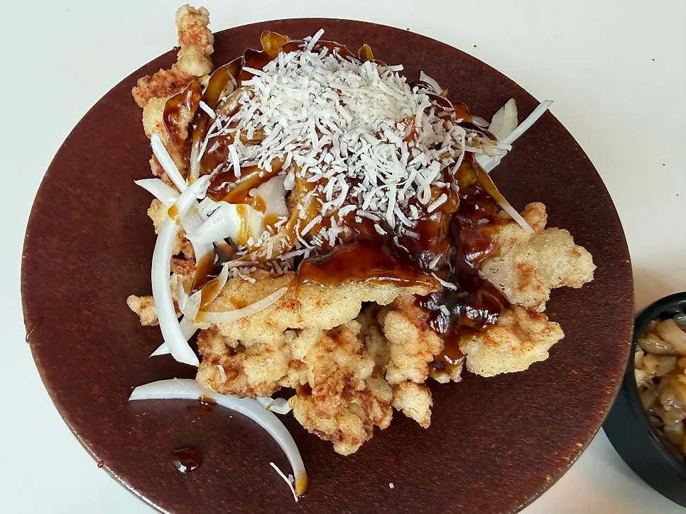 A plate of black vinegar sirloin sweet and sour pork topped with onions