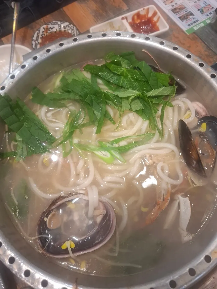 Udon noodles added into the clam hot pot broth