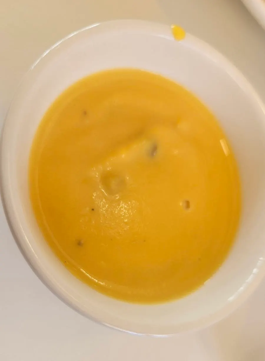 Tearing off pastry to dip into the pumpkin soup