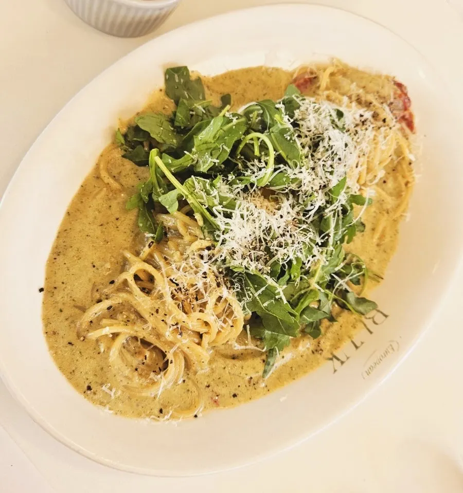 Basil pesto cream pasta topped with arugula