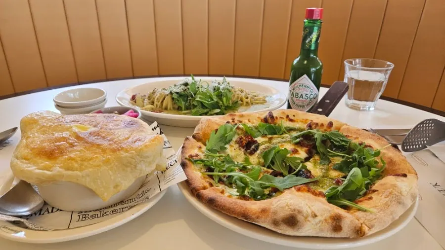 Soup, pasta and pizza served together on the table