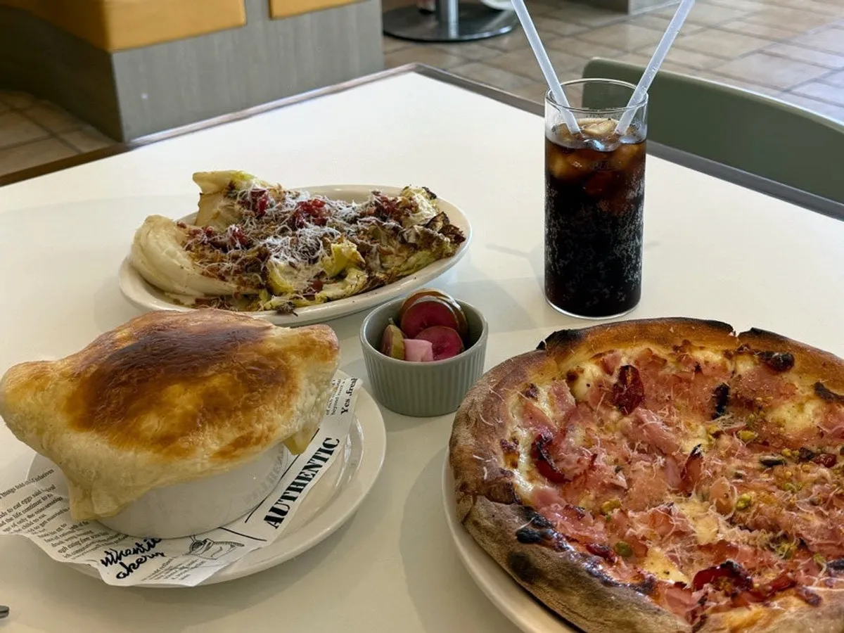 Table spread of pastry soup, salad, and jambon pizza