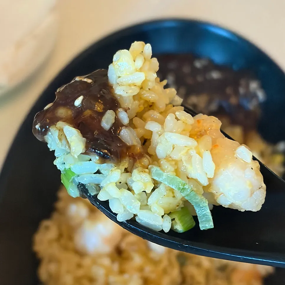 A spoonful of fried rice with plump shrimp