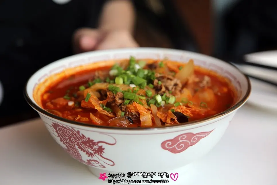 Noodles lifted up from a bowl of chili jjajangmyeon