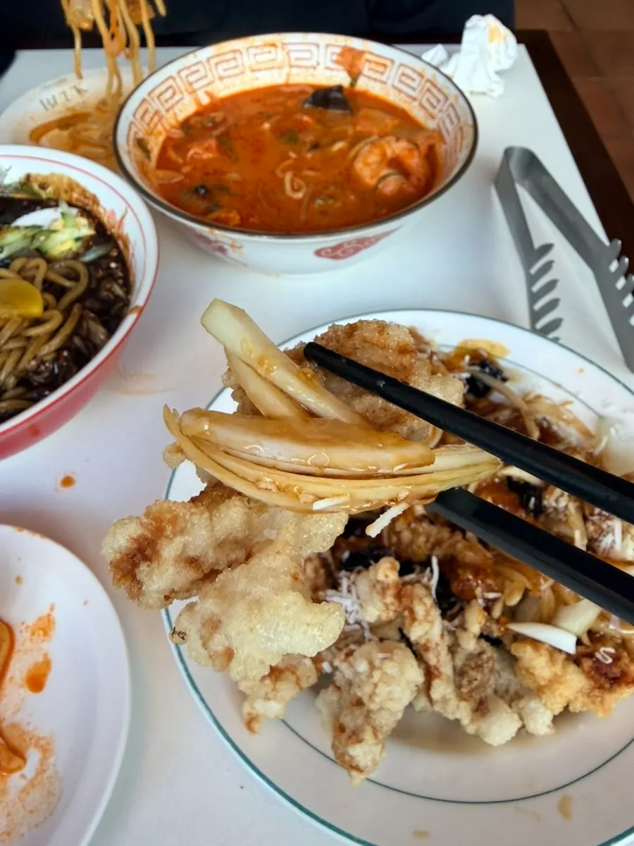 탕수육 한 점을 집어 든 모습