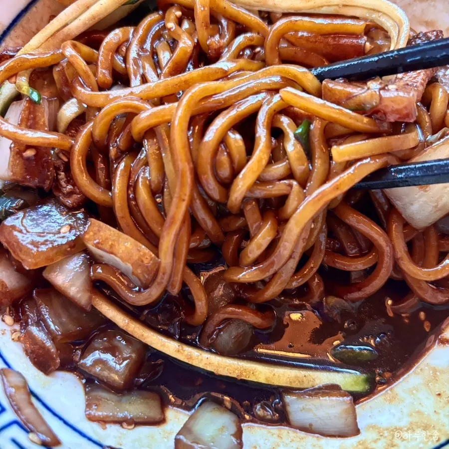 Jjajang noodles mixed with a broken poached egg