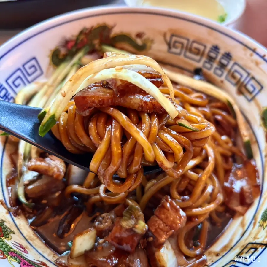 Close-up of jjajang with pork belly pieces